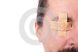 ManÂ´s eye glued medical plaster, isolated on white, concept fir