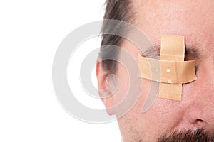 ManÃÂ´s eye glued medical plaster, isolated on white, concept fir photo