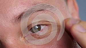 Man's eyes, brown area surrounding pupil is iris
