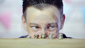 The man`s eyes look at the coins. Sly eyes. close up