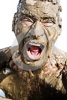 Man's face is very dirty in the mud