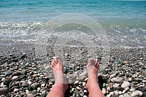 Man`s feet on the beach
