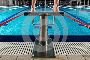 Man`s feet standing on the starting blocks