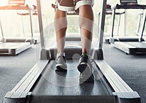 Man`s feet on treadmill in fitness club, healthy lifestyle