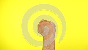 Man's fist knocking door gesture knock-knock who there on a yellow background.