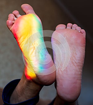 Man`s foot in the color of the rainbow