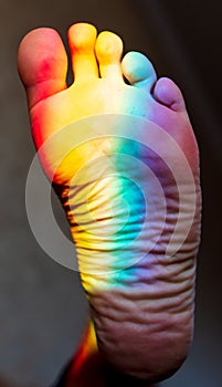 Man`s foot in the color of the rainbow