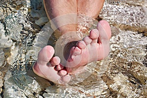 Man's foots in sea water