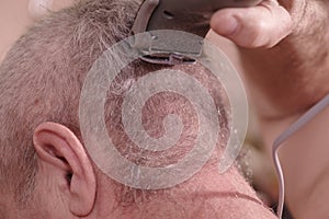 A man is cut hair on his head.The man`s hairstyle in hairdressing salon