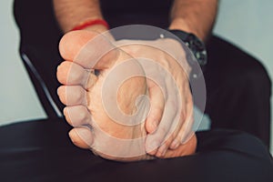 Man's hand being massaged a foot, Man with painful and inflamed gout on his foot around the big toe area.