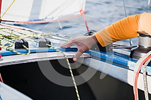 Man`s hand with boat rope. Yachtsman moors his motor boat at jetty. Close up hands and bow of the boat.