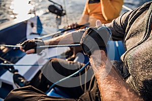 Man`s hand with boat rope. Yachtsman moors his motor boat at jetty. Close up hands and bow of the boat.