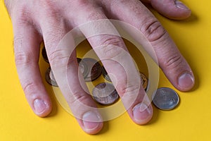 The man`s hand covered the coins. Protecting your money. Lack of money