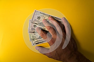 The man`s hand covered the dollars banknotes. Protecting your money. Lack of money. Dollars banknotes closeup