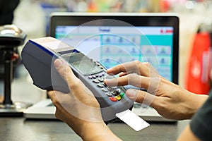 Man's hand with credit card swipe through terminal