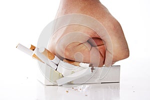 Man's hand crushing cigarettes