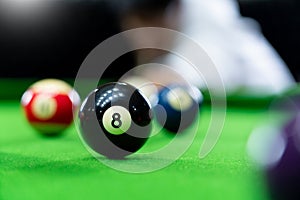 Man`s hand and Cue arm playing snooker game or preparing aiming to shoot pool balls on a green billiard table