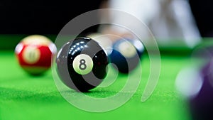 Man`s hand and Cue arm playing snooker game or preparing aiming to shoot pool balls on a green billiard table