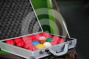 Man`s hand and Cue arm playing snooker game or preparing aiming to shoot pool balls on a green billiard table. Colorful snooker