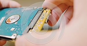 Man's hand disconnect sata control board hard drive for an external drive pocket. Close-up. Concept is to