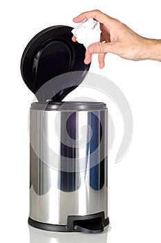 Man's Hand disposing of trash in stainless steel trash can