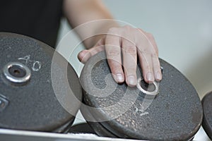 Man's hand on dumbbell weight