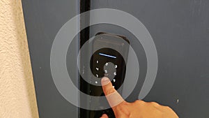 A man's hand enters an electronic code for a door lock. A modern way to protect against burglary and theft, close-up