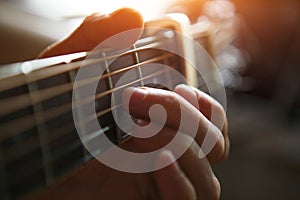 A man`s hand on the fretboard of a guitar runs his fingers through the strings and clamps the chords. Instrumental music, guitar