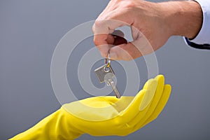 Man`s Hand Gives The Keys To Cleaner`s Hand