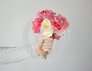 Man's hand giving bouquet of flowers