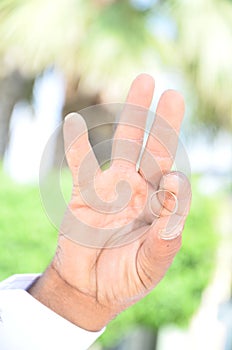 A man`s hand with a gold wedding ring on his finger