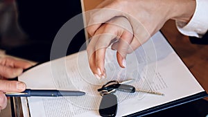 Man`s hand grabs woman`s hand, which tries to take car keys from table.