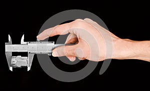 Man's hand holding a caliper during measuring