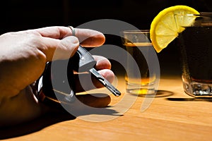 A man`s hand holding car keys at a bar