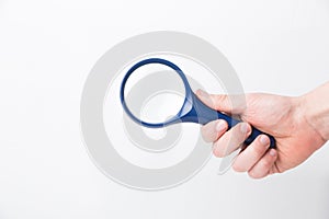Man's hand, holding classic styled magnifying