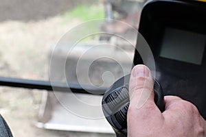 Man`s hand holding a control joystick in excavator.