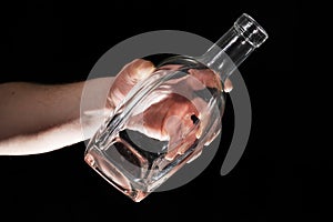 Man`s hand holding empty bottle of alcohol
