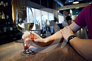 Man's hand holding glass of white wine