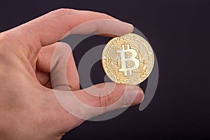 Man`s hand holding golden Bitcoin