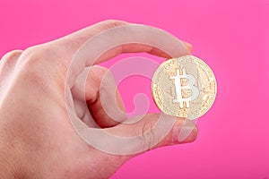 Man`s hand holding golden Bitcoin