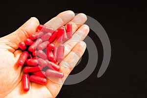 Man`s hand holding a handful of medicine pills, to treat addictive diseases