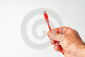 Man& x27;s hand holding internet cable on white background