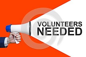 Man`s Hand Holding Megaphone With Speech Bubble VOLUNTEERS NEEDED. Announcement And Advertising photo