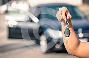 Man's hand holding modern car keys ready for rental