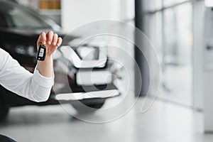 Man's hand holding modern car keys ready for rental. car buyer's hand with keys