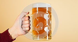 Man& x27;s hand holding mug of beer. Bavarian beer. Oktoberfest festival. Fresh cold beer in glass. Male hand with full