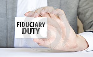 man's hand holding paper sheet with fiduciary duty words