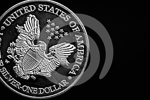 Man's hand holding a silver American coin, close-up of a quarter dollar coin isolated over black. Bag, dollars