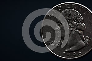 Man's hand holding a silver American coin, close-up of a quarter dollar coin isolated over black. Bag, dollars