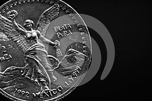 Man's hand holding a silver American coin, close-up of a quarter dollar coin isolated over black. Bag, dollars